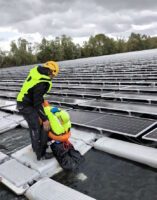 Technicien équipé d’un gilet de sauvetage sur plateforme photovoltaïque flottante (FPV)